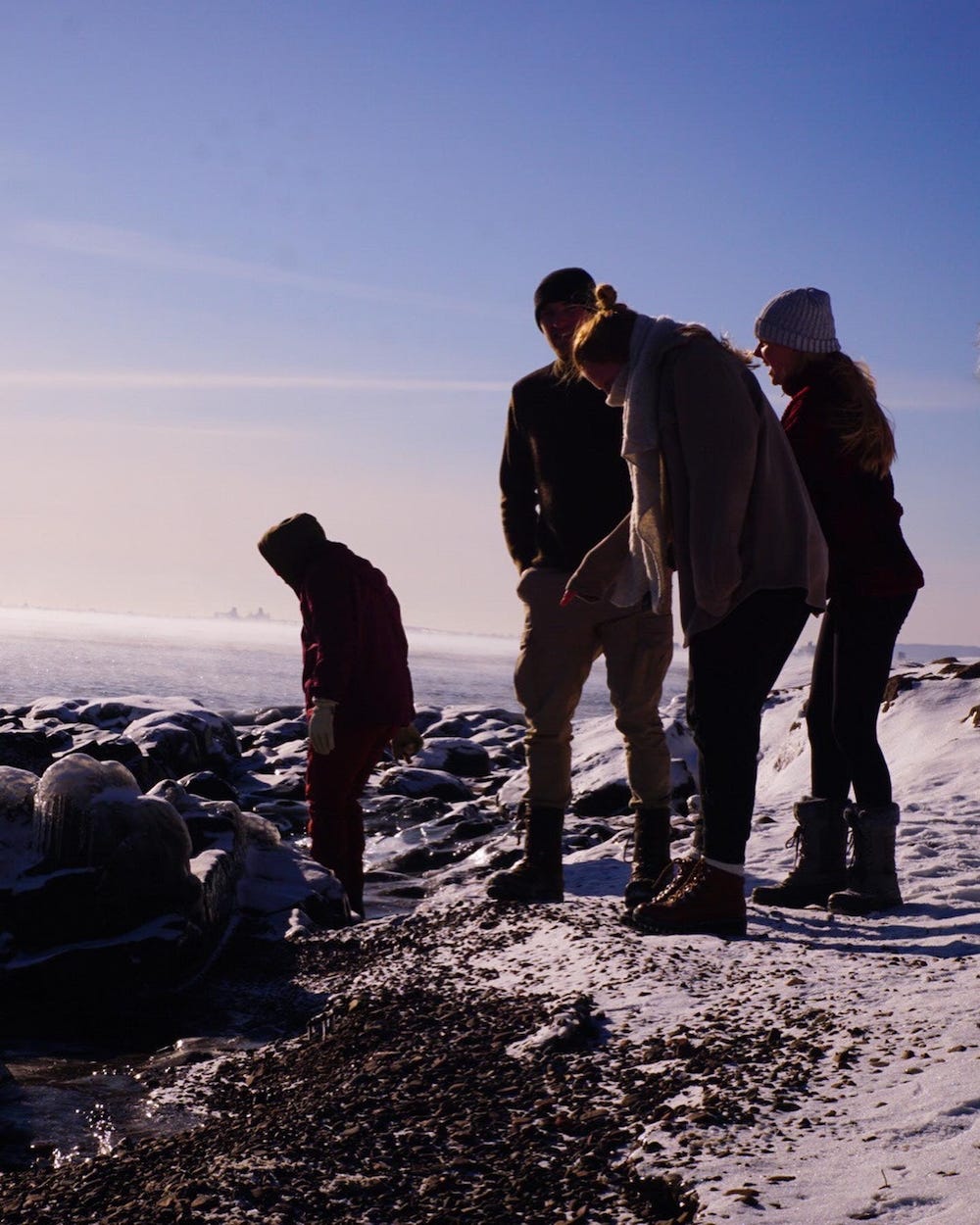 Picture shows friends by the lake, bundling up trying to stay warm. Picture shows friends by the lake, bundling up trying to stay warm.