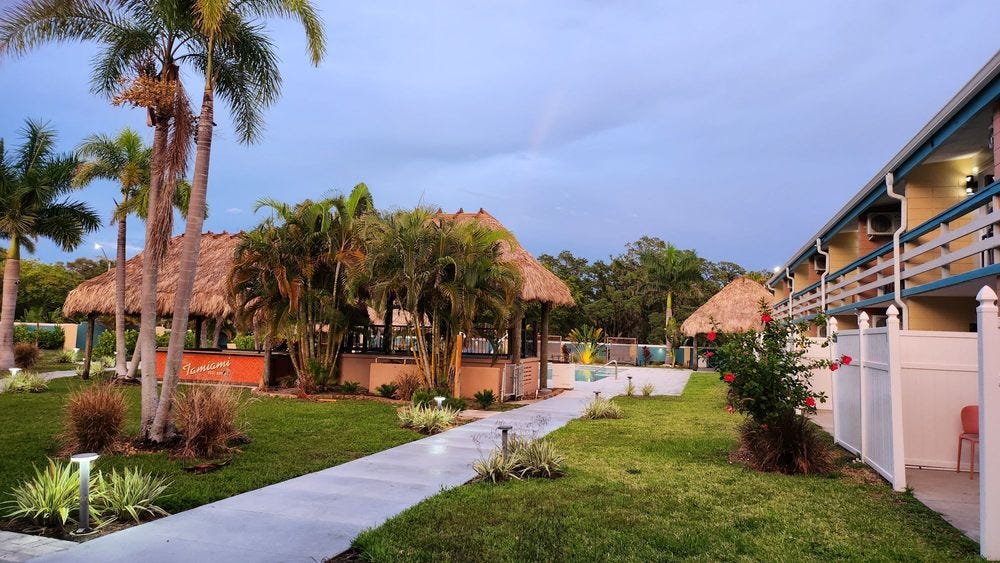 Photo of the pool area at the Golden Host, complete with a tiki bar hut style patio enclosure. 