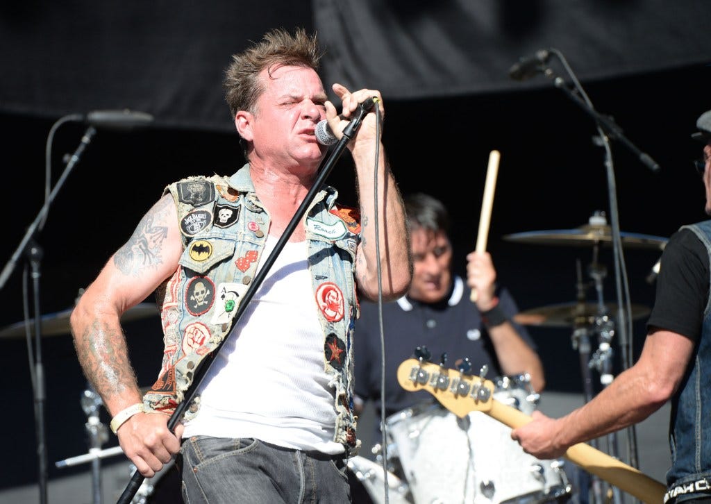 David Roach singing into a microphone during a concert David Roach singing into a microphone during a concert