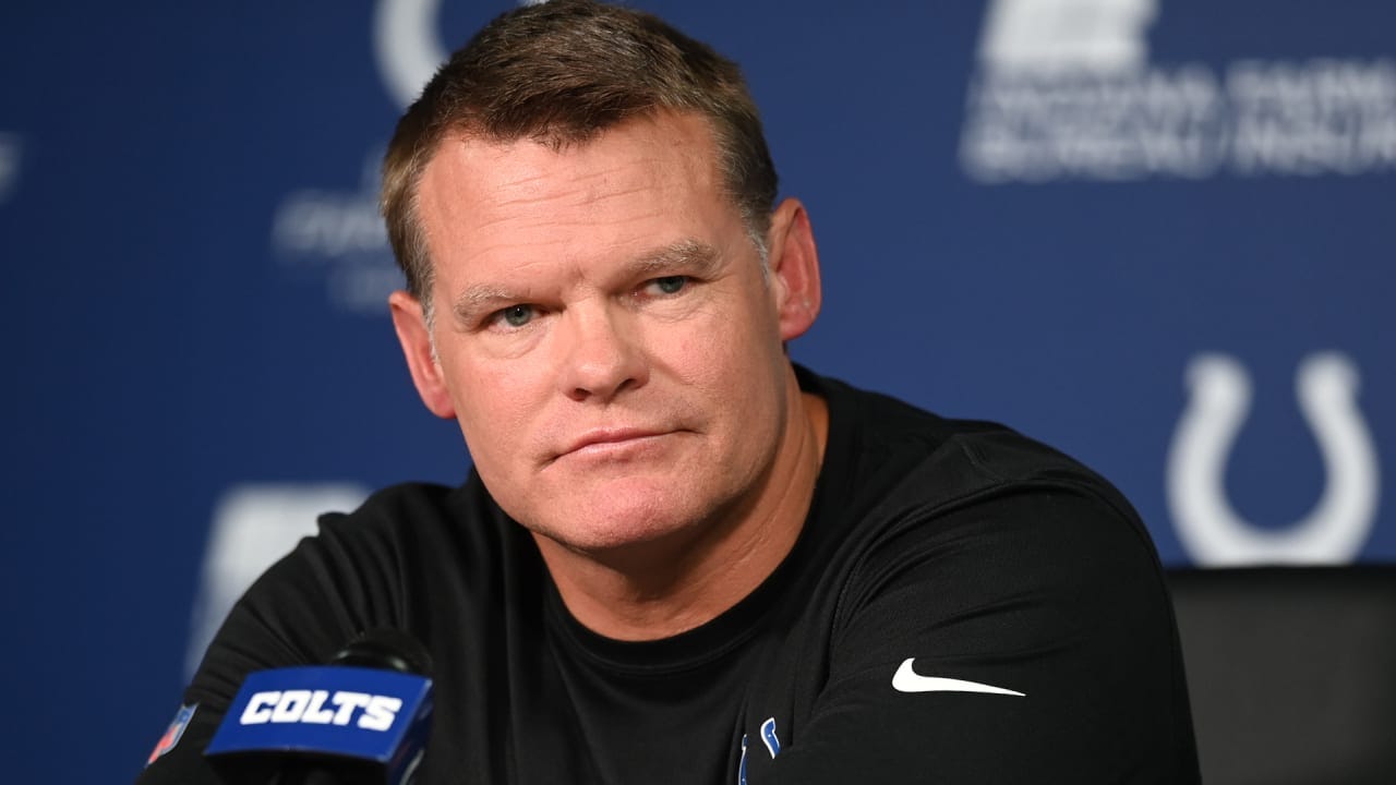 Chris Ballard speaks at a press conference with Indianapolis Colts logos in the background.