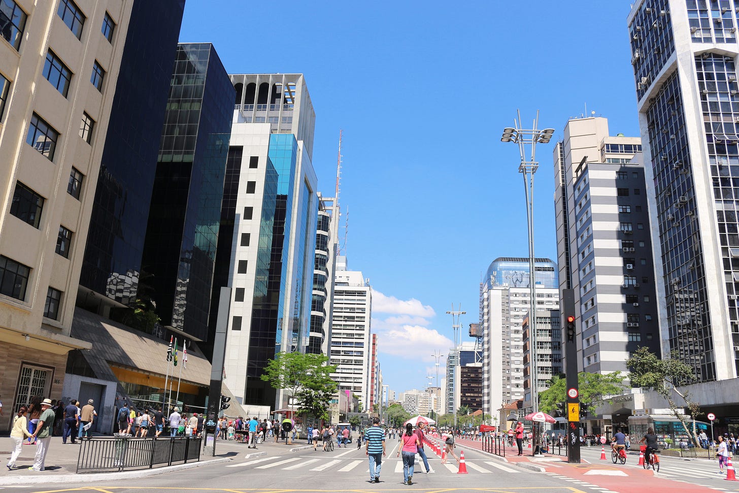 Avenida Paulista durante o dia, com pistas fechadas para carros e pessoas circulando.