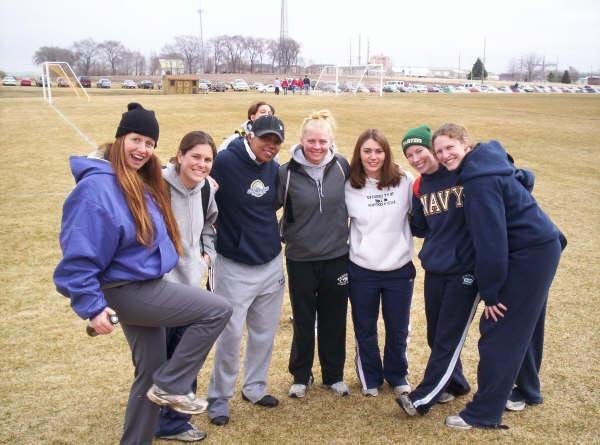 Rugby players stand in a group on the rugby pitch. Rugby players stand in a group on the rugby pitch.