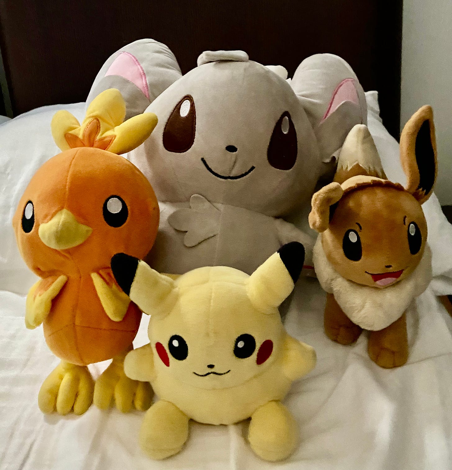 4 Pokemon character stuffed animals together