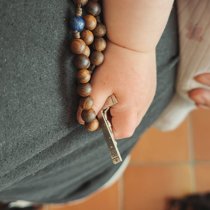 Amelia Teresa holds my rosary while falling asleep. Leon walking through the water.