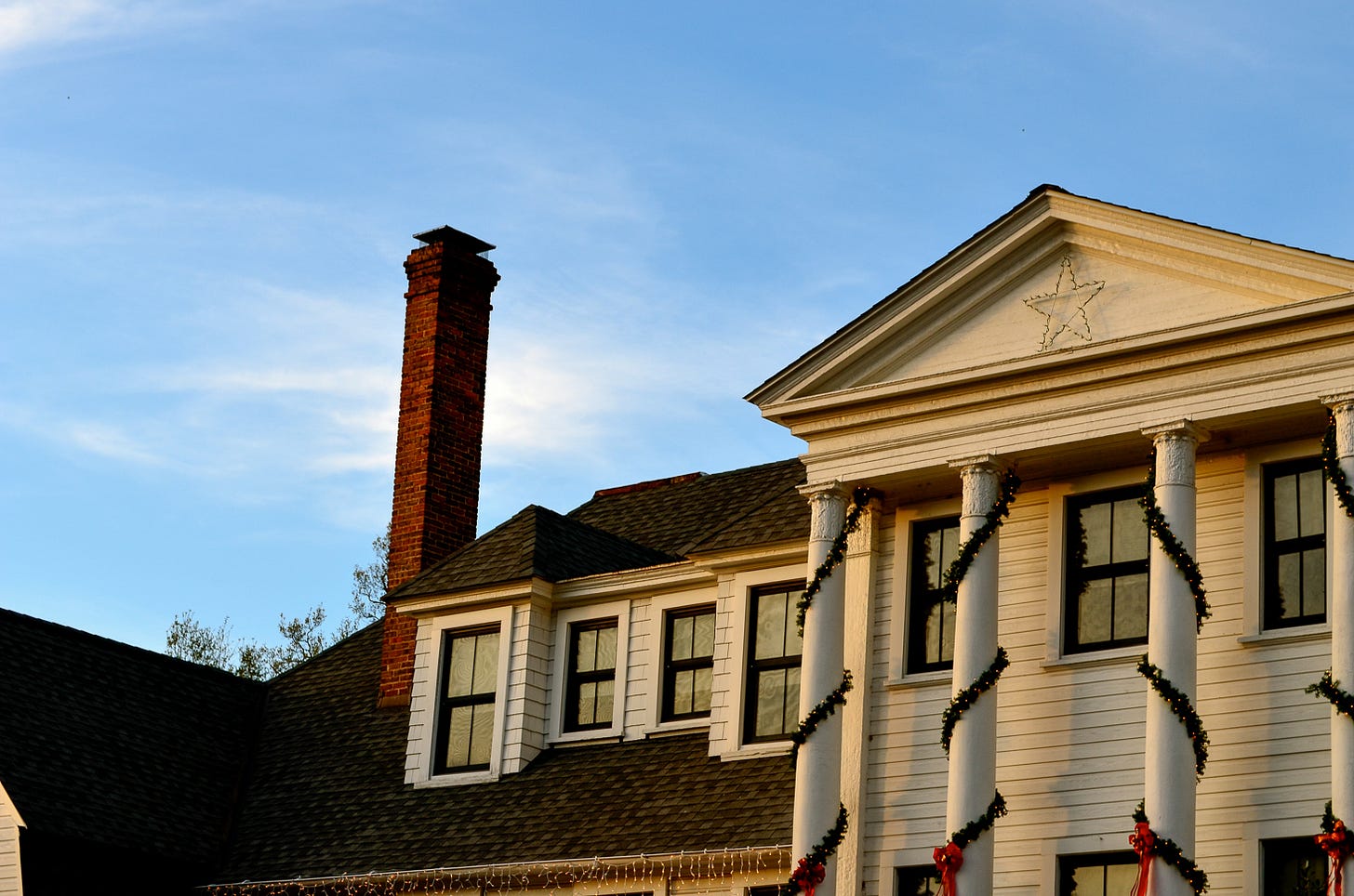 A large house with a chimney and holiday decorations.