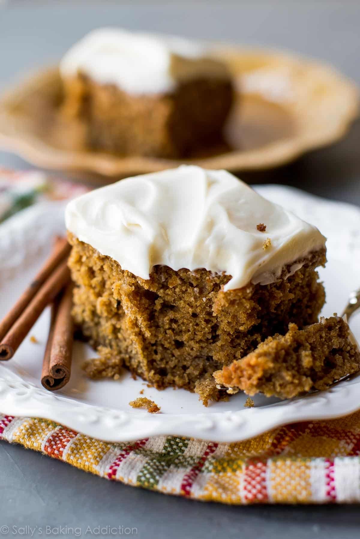 slice of spice cake with cream cheese frosting on a white plate