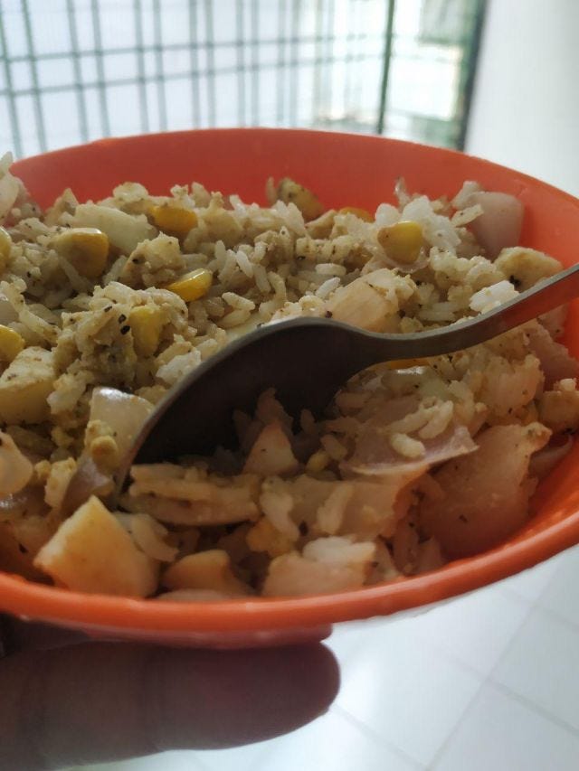 An orange bowl of fried rice with eggs and corn. An orange bowl of fried rice with eggs and corn.