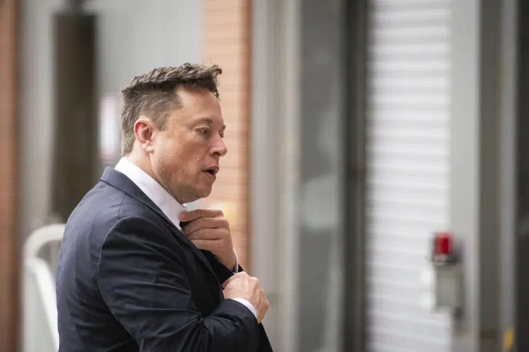 Elon Musk adjusting his tie outside, Tesla and Twitter CEO known for blunt internal emails. Elon Musk adjusting his tie outside, Tesla and Twitter CEO known for blunt internal emails.