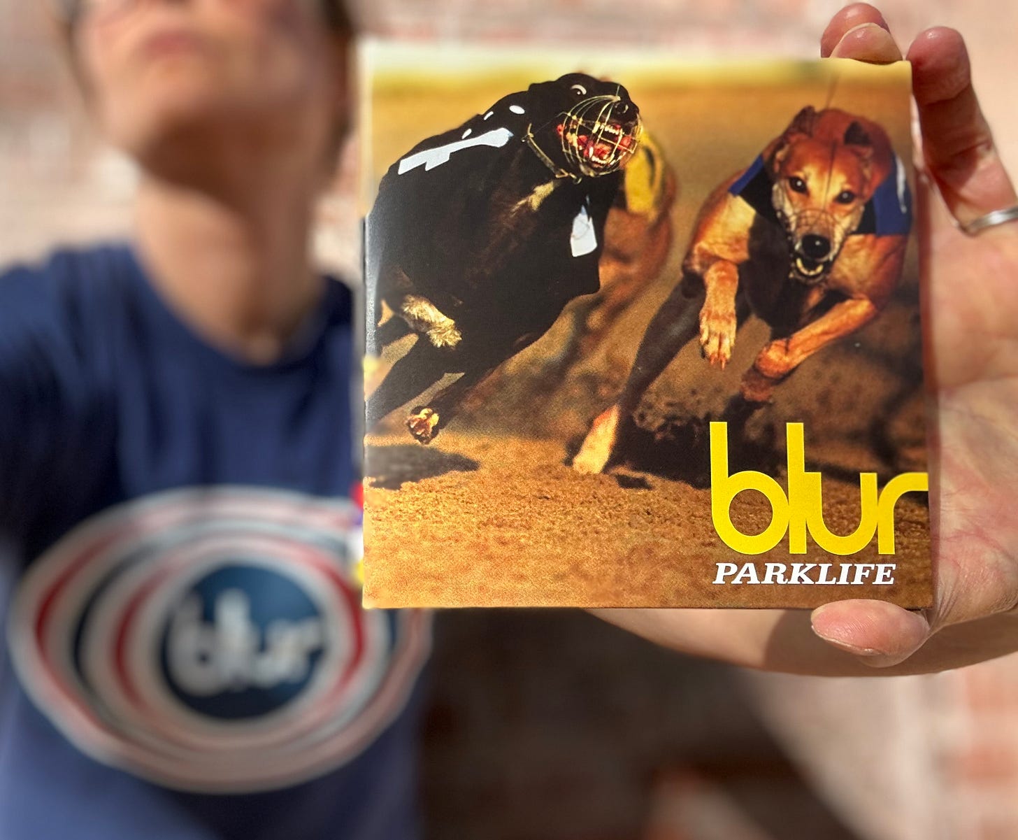 White woman in Blur Parklife t shirt holding up Blur Parklife CD