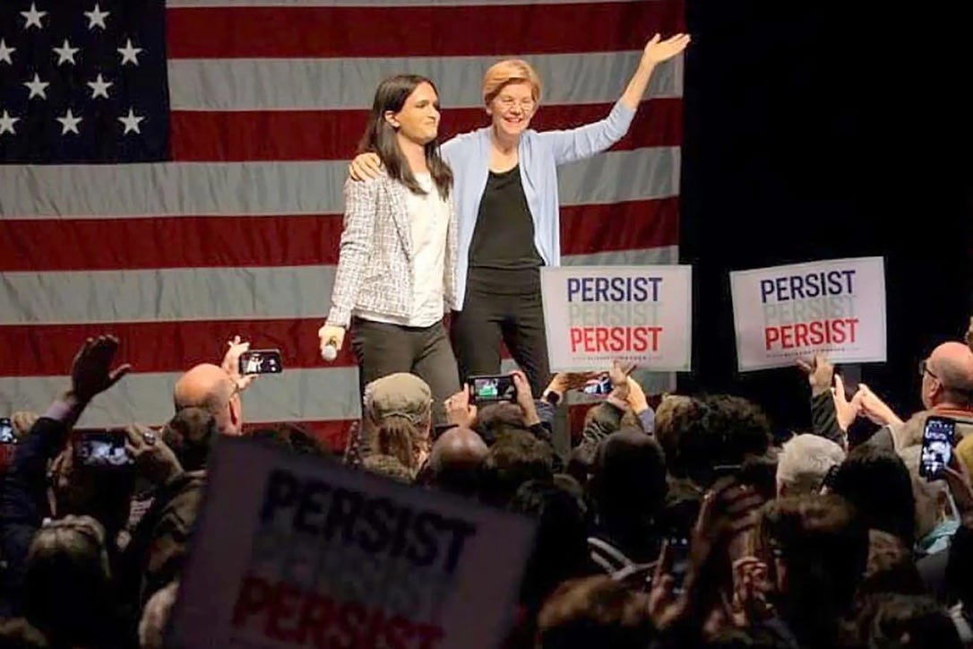 A group of people standing on a stage with signs

AI-generated content may be incorrect.