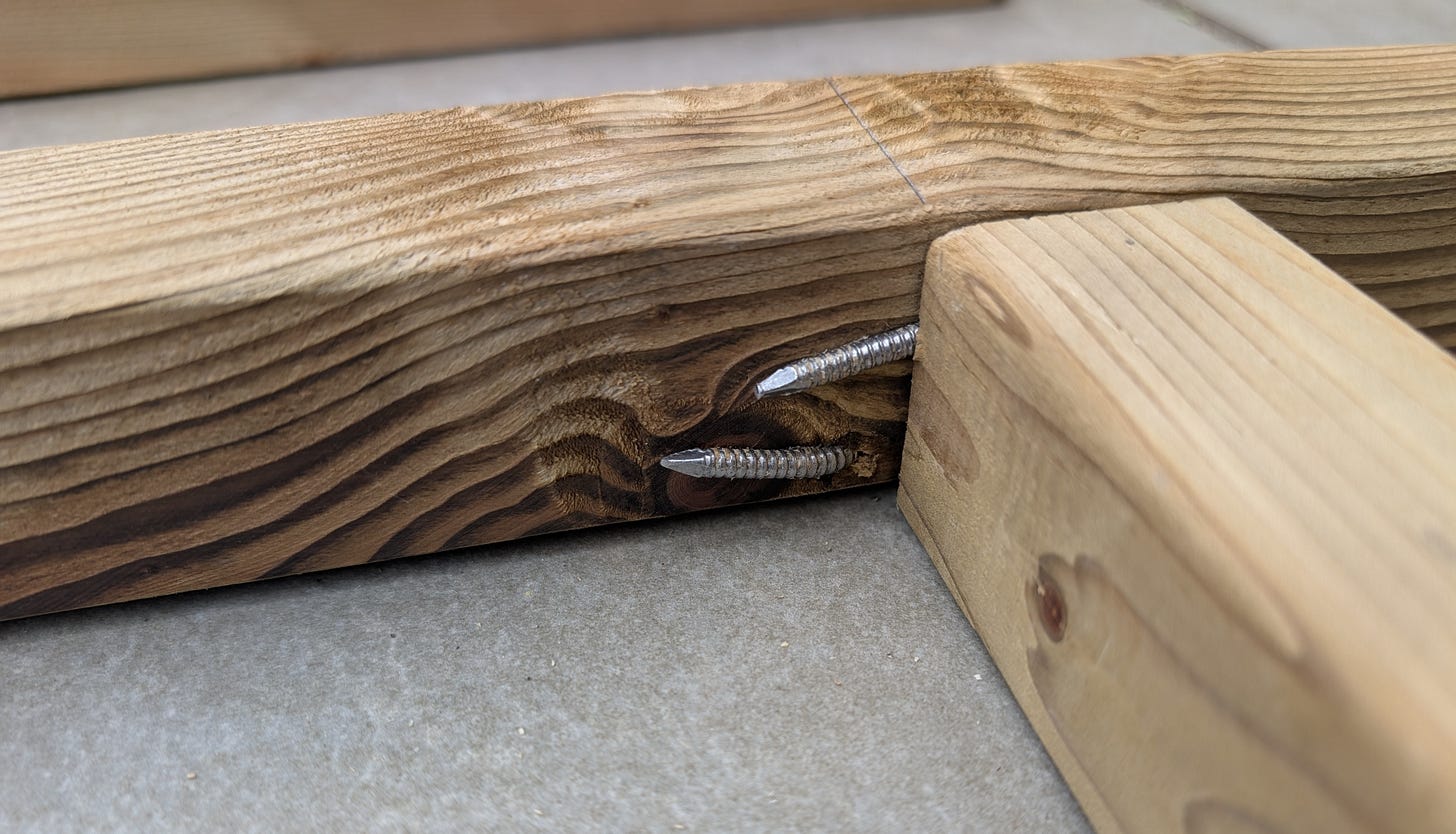Bent nails in a wooden shed frame, illustrating a misaligned joint that needed repair