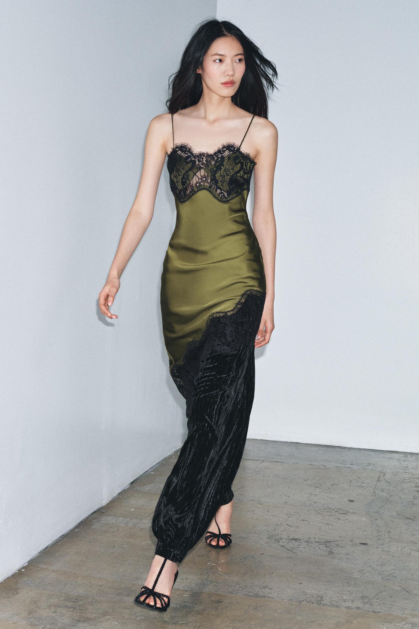 Green dress set with black lace on the neckline and a long black pleated skirt. Green dress set with black lace on the neckline and a long black pleated skirt.