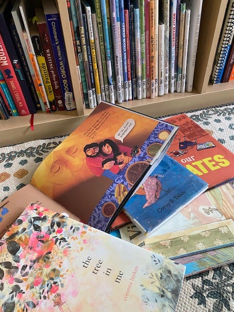 A pile of books on a carpeted floor with the corner of a bookshelf filled with books is in the background. A pile of books on a carpeted floor with the corner of a bookshelf filled with books is in the background.
