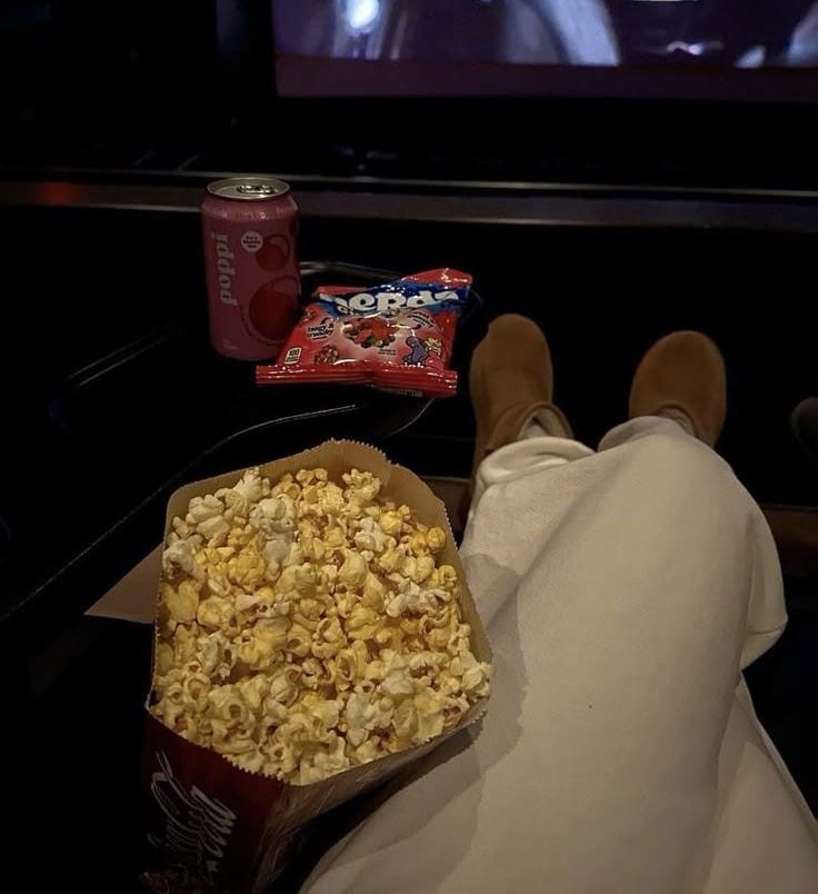 This may contain: someone is watching tv and eating popcorn