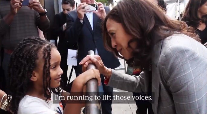 video screenshot of Kamala Harris leaning down to speak to a young Black girl behind a security barrier during an event. Caption of audio: 'I'm running to lift those voices.'