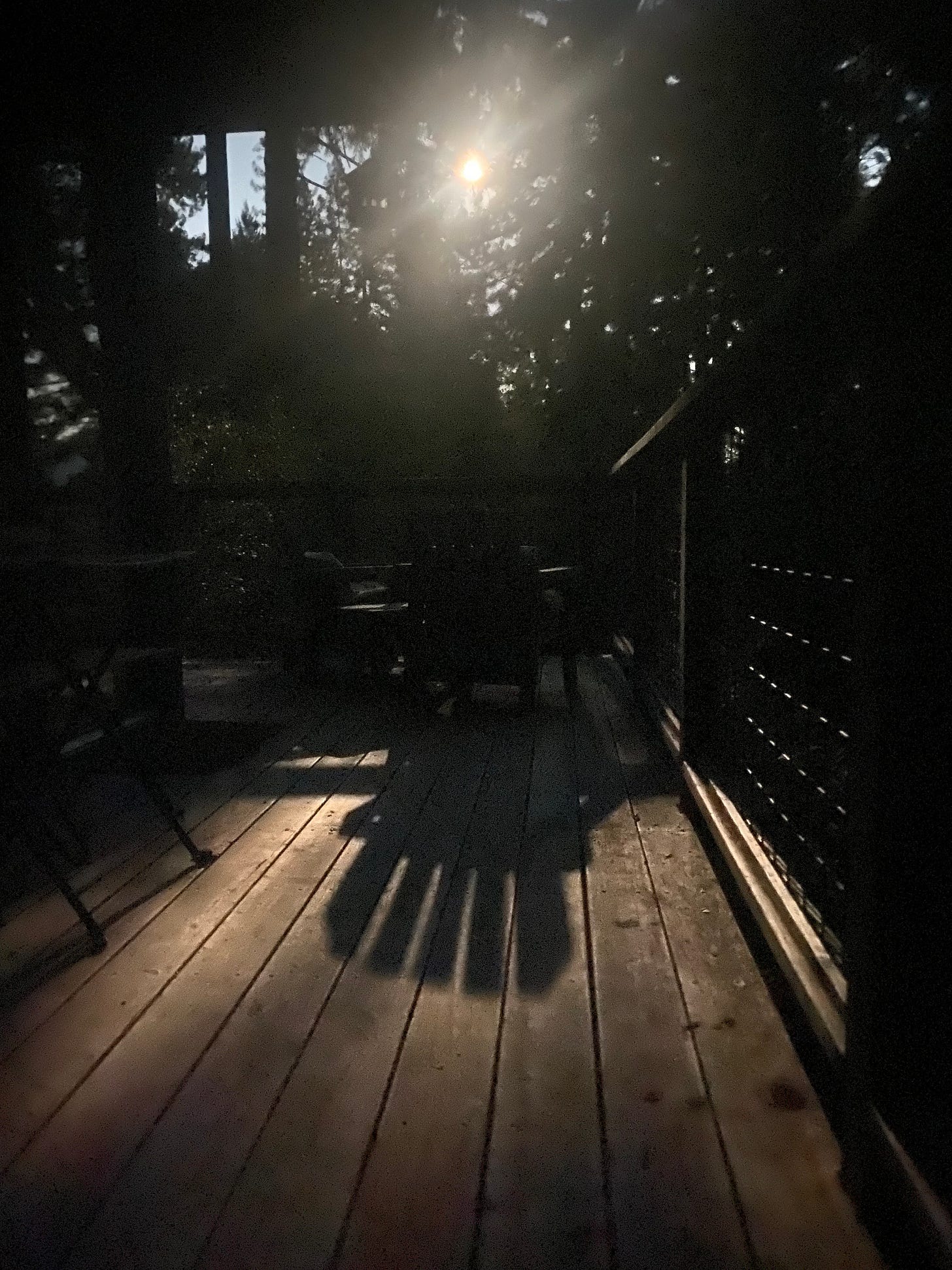 Moonlight casting a shadow through an Adirondack-style chair on a deck Moonlight casting a shadow through an Adirondack-style chair on a deck