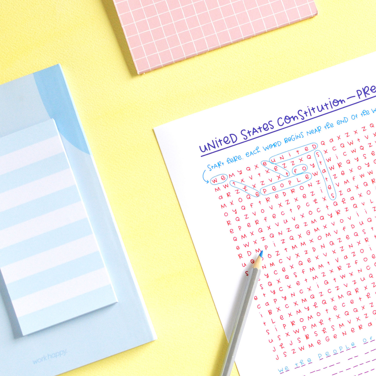 Colourful, handwritten journal page on yellow background shown with colourful pencil and notebooks.