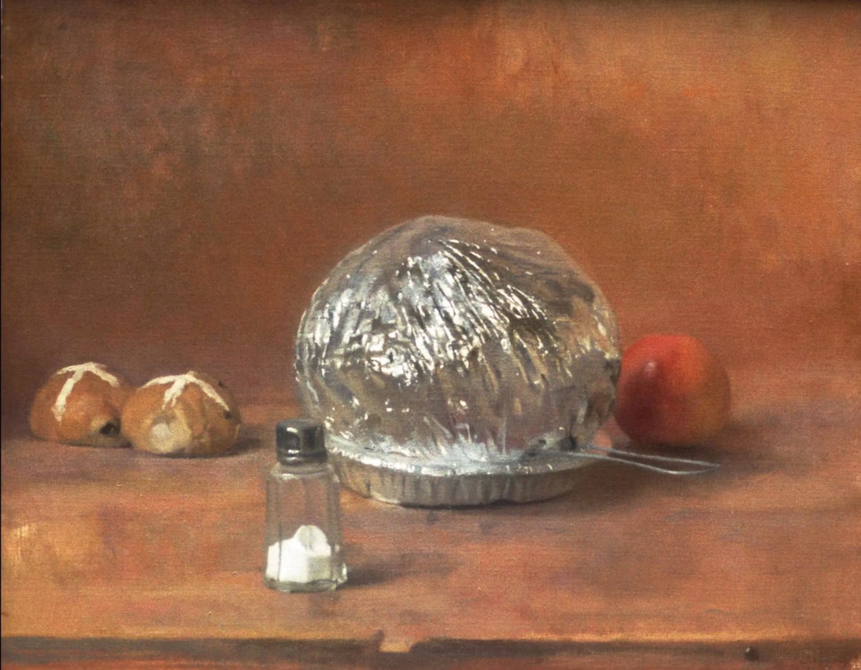 A still life featuring an expanded Jiffy Pop and resting on a wooden table top with two hot cross buns, an apple, and a salt shaker in the foreground. 