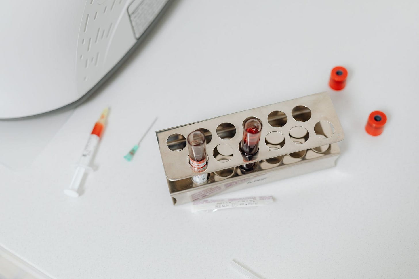 Photo by https://kaboompics.com/ on Pexels High-angle shot of lab test tubes and syringe on a white surface, perfect for science and medical themes. (stock photo)