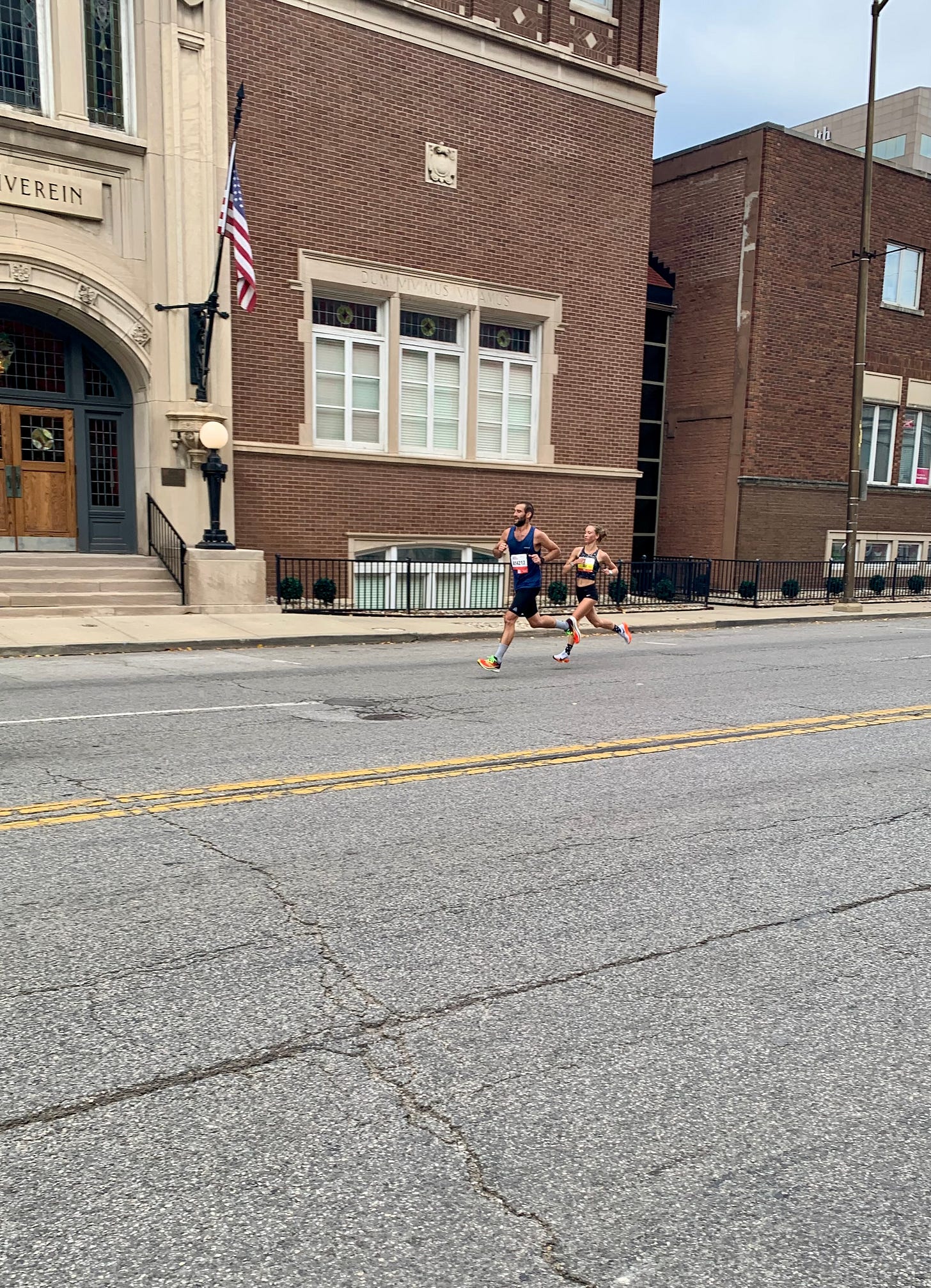 The final two miles of the Indianapolis Monumental Half Marathon. A woman and a man run together down the street.