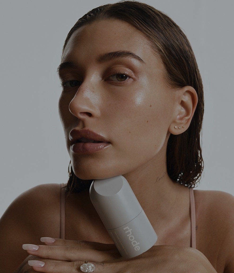 rhode skincare product held up to the face in a clean girl aesthetic beauty campaign rhode skincare product held up to the face in a clean girl aesthetic beauty campaign