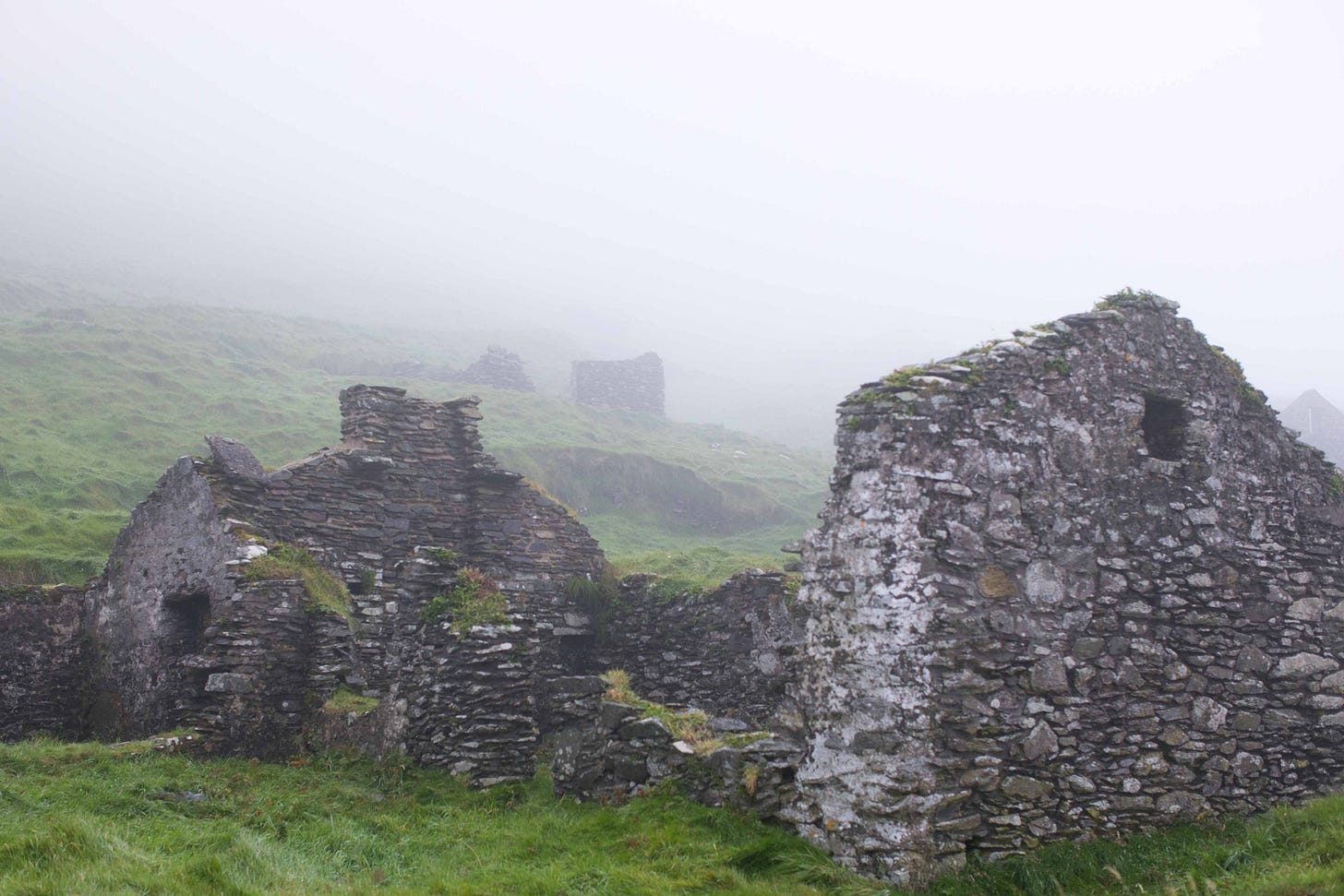Old ruins of cottages remain on Great Blasket Island, Ireland. These were photographed in fog during September 2020, the first autumn of pandemic. Old ruins of cottages remain on Great Blasket Island, Ireland. These were photographed in fog during September 2020, the first autumn of pandemic.