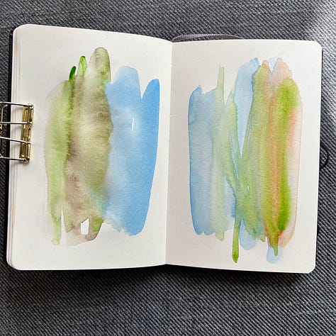 Different pages in a small sketchbook painted with light washes of watercolor in a variety colors