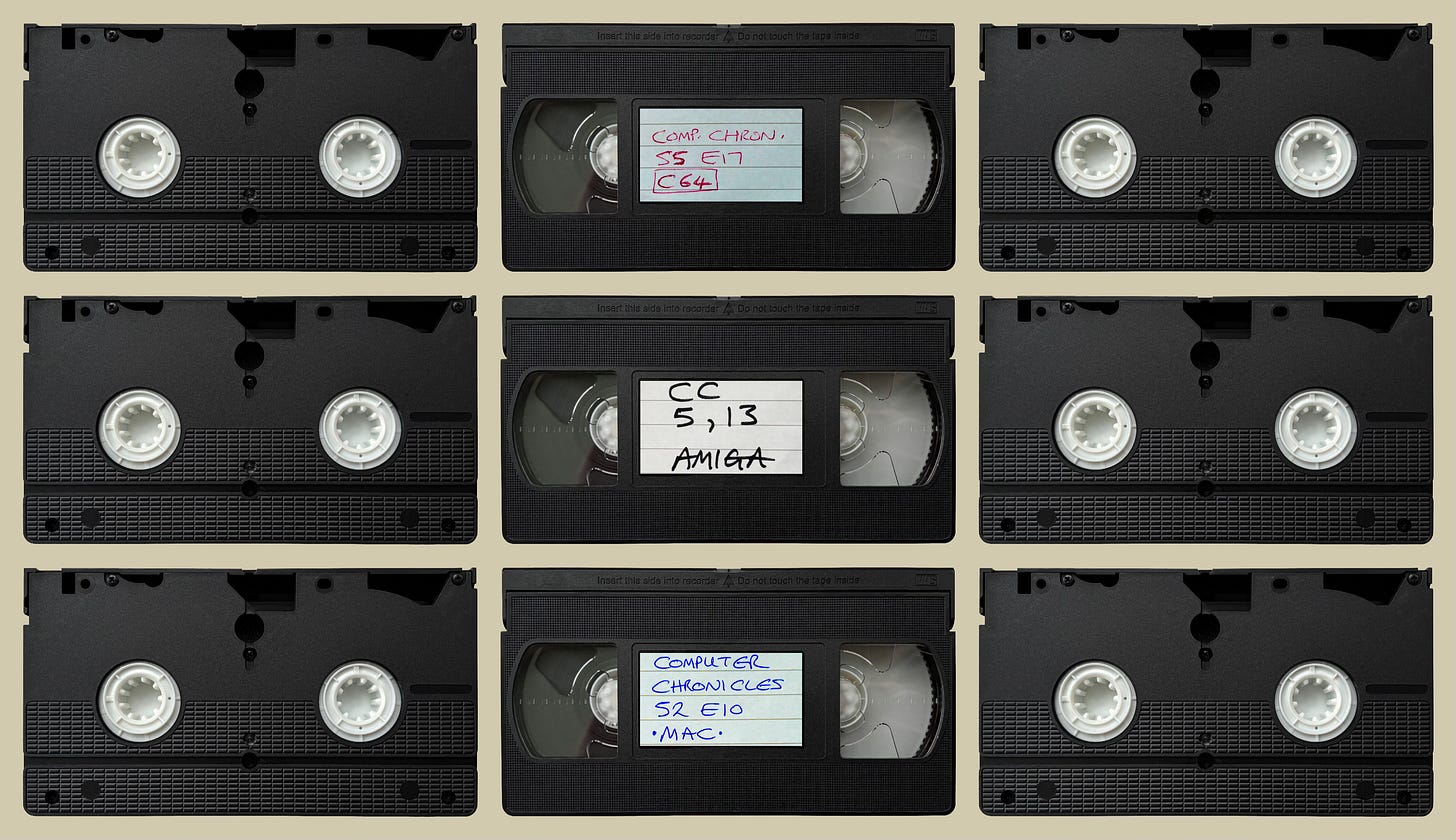 Nine VHS video cassette tapes, the outer six being upside down. The centre three are the right way up and labelled to indicate they contain the Computer Chronicles, season 5 episode 17 (C64), season 5 episode 13 (Amiga), and season 2 episode 10 (Mac). 