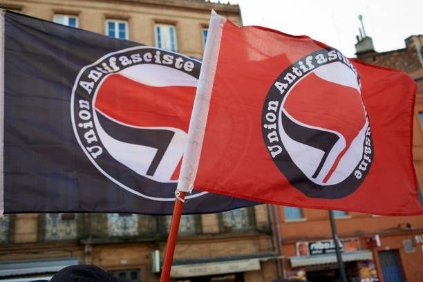 Two antifascism flags during a gathering in Toulouse in solidarity with anti-fascists in Charlottesville after the killing of Heather Heyer by a...