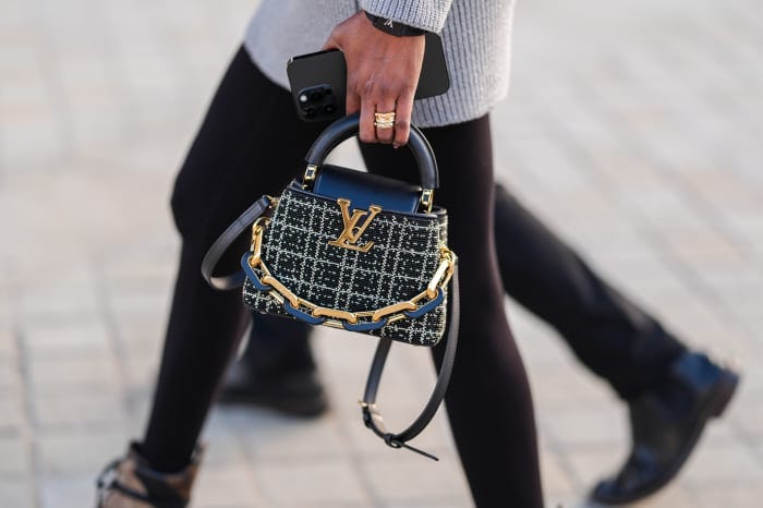 Woman carrying a Louis Vuitton handbag.