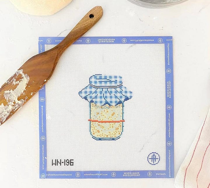 needlepoint canvases of boat and tote, sour dough starter, slice of cake and butterfly clips