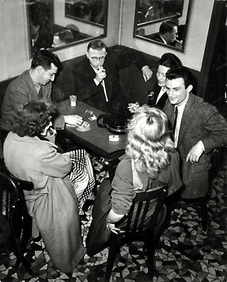 This may contain: a group of men and women sitting around a table playing card games in a restaurant This may contain: a group of men and women sitting around a table playing card games in a restaurant