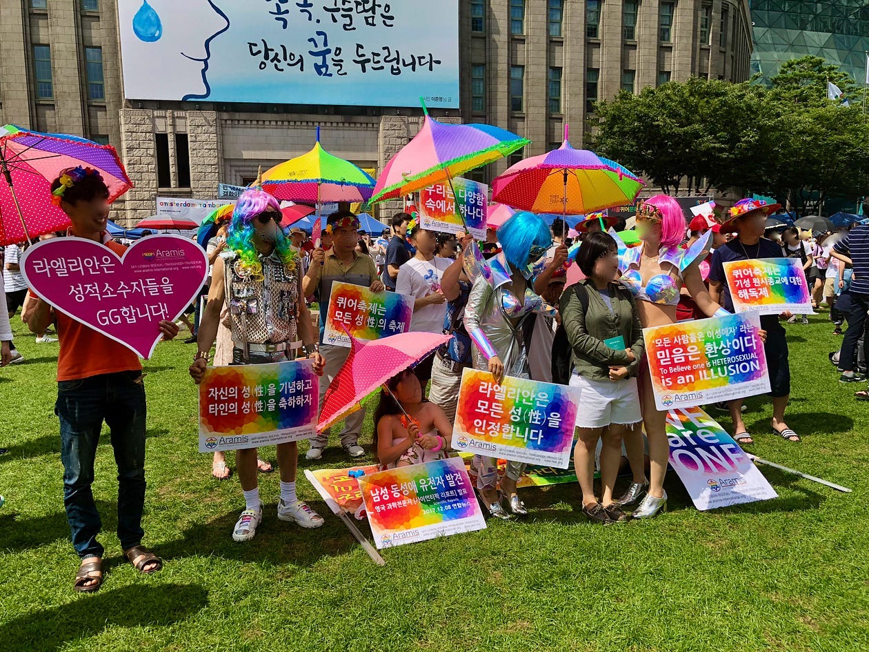 A group of Raëlians in colorful attire smile and pose with a festival goer