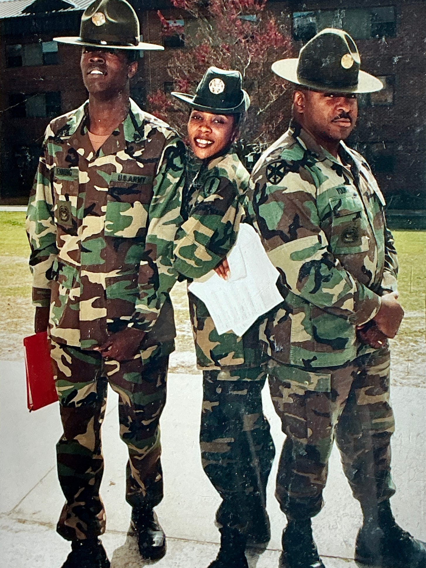 2 black male drill Sargents with a female drill sargeant in between posing for a picture
