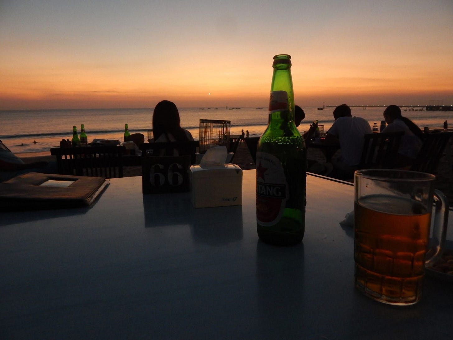 Table for one with beer overlooking the beach.