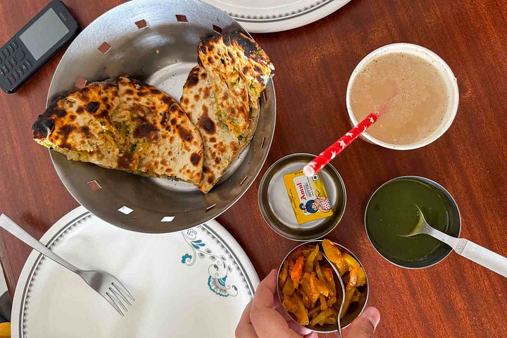 A mixed spread of vegetable pakoras and Amritsari kulcha with pickles and coriander mint chutney