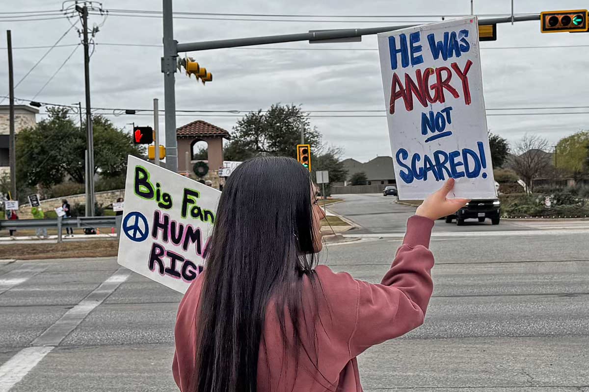 Woman holding protest signs at Women's March Free America Walkout