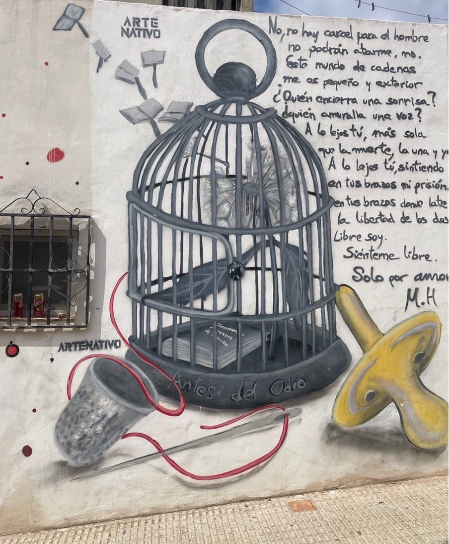 A photo of another graffitied wall. The central image is an ornate bird cage, and there's a poem written to the right.