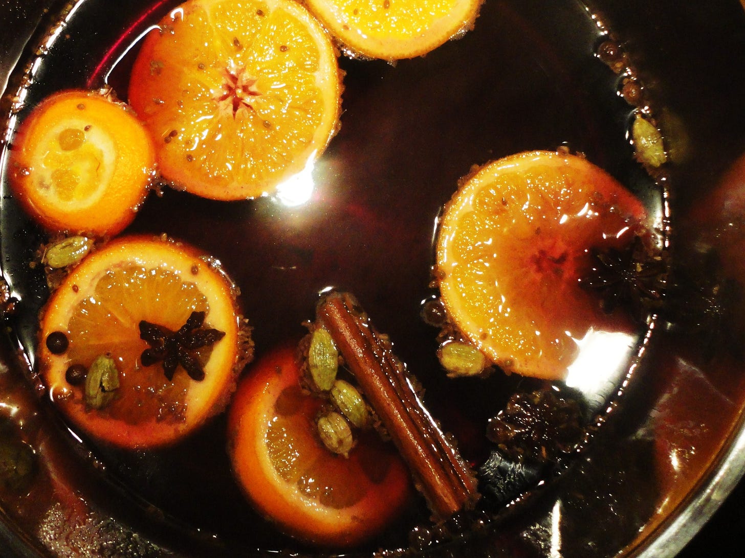 Mulled wine in a pot with spices and slices of orange. CC Angela Huster