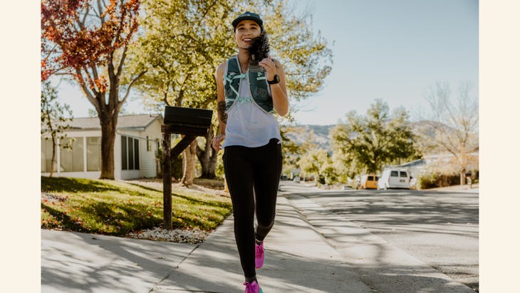 a woman runs by herself with a smile on her face