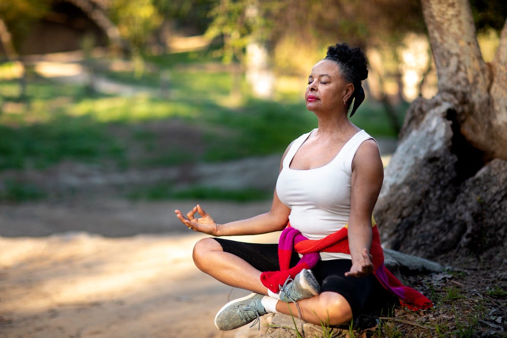 Woman meditating under a tree.