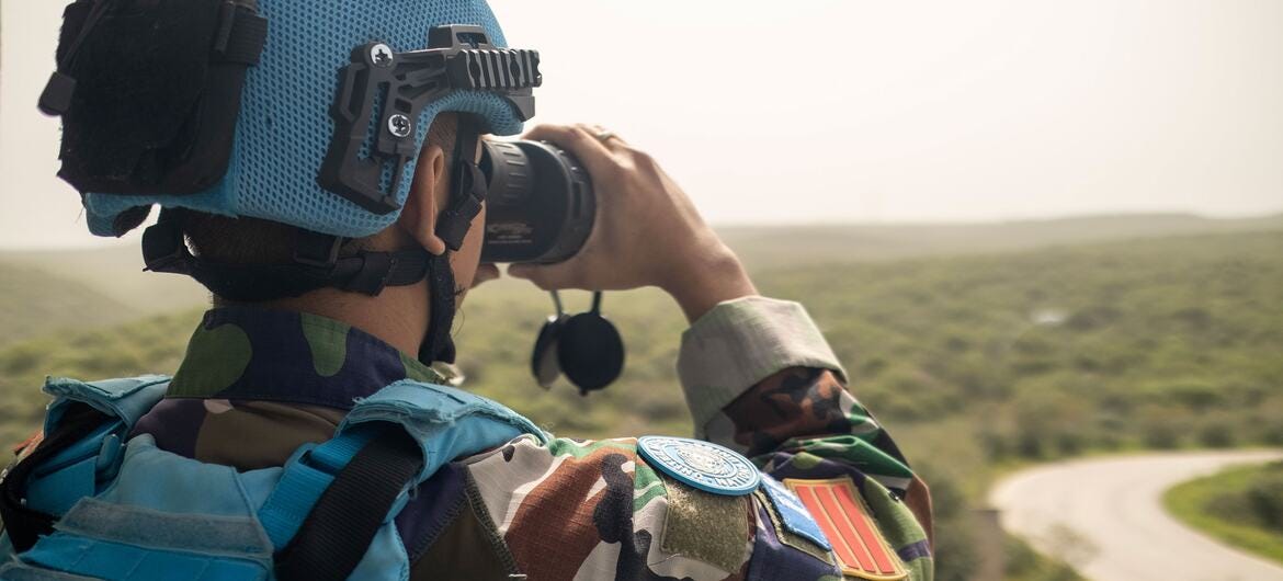 A UNIFIL Indonesian peacekeeper uses binoculars to observe the Green Hill area near Naqoura headquarters in Lebanon.
