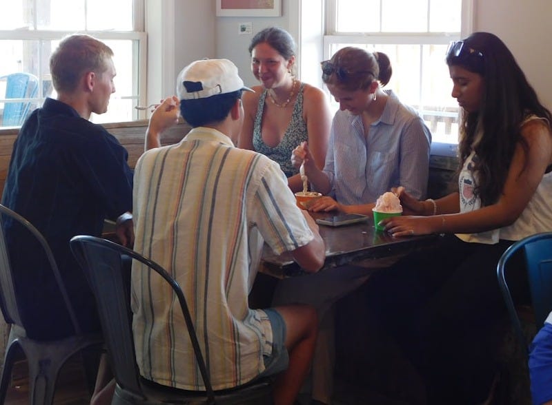 Group of friends sitting around a table indoors. Group of friends sitting around a table indoors.