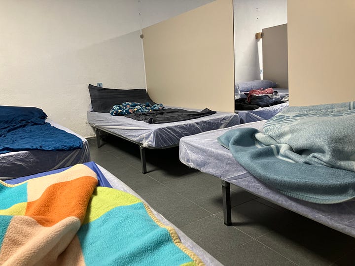 a cobblestone trail leading up a hill through grass and a dorm room with four cots in a hostel