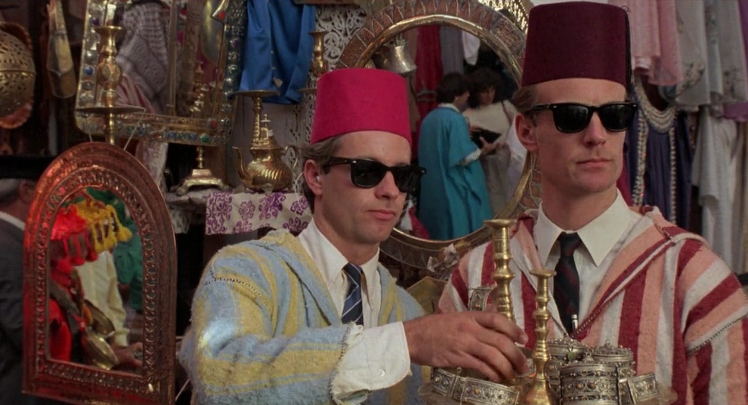 Two CIA agents in sunglasses attempt to blend in at a Morroccan street market