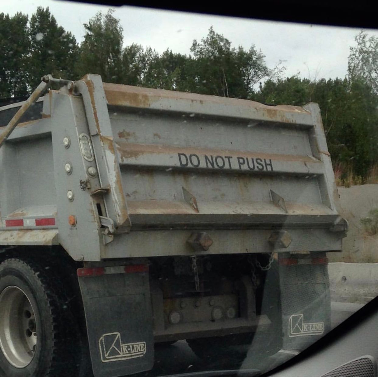 A dump truck with the words "DO NOT PUSH" on the back.