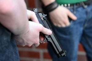 Man's hands holding a gun