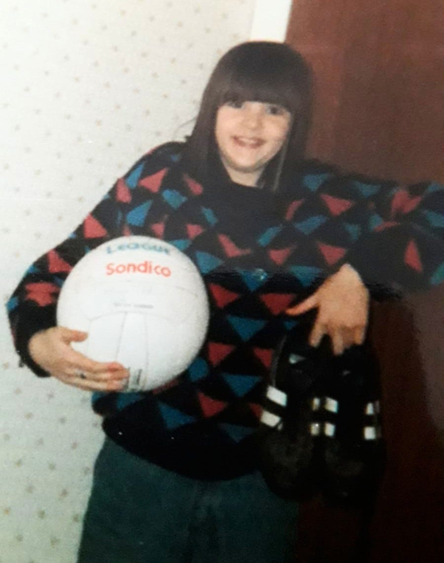 10-year-old Clare proudly displays her white, Sondico football and black boots with two white stripes