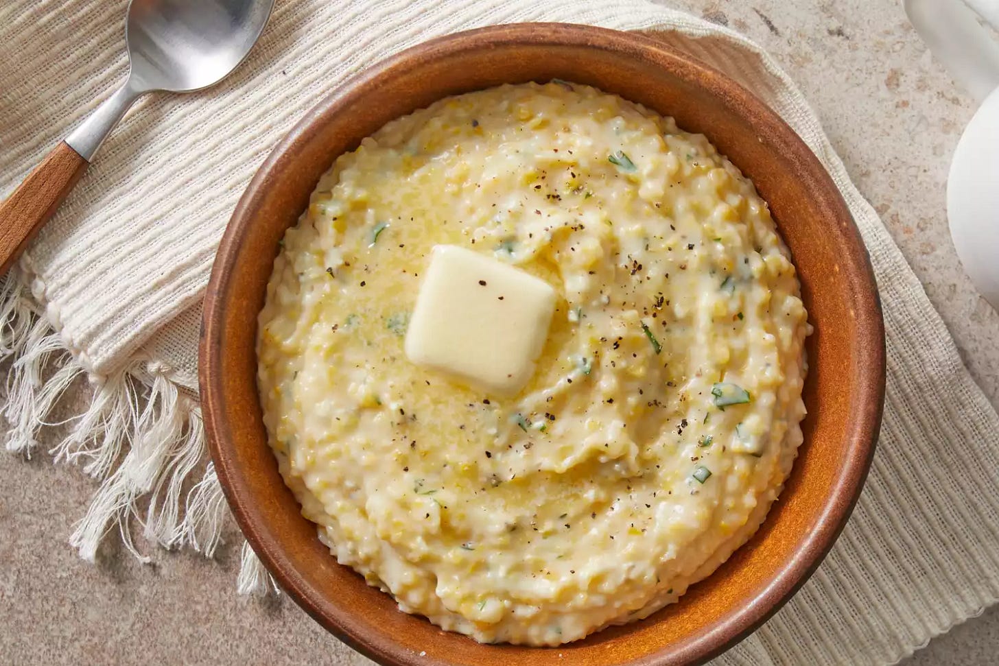 Cooked grits with a slice of butter melting on-top 