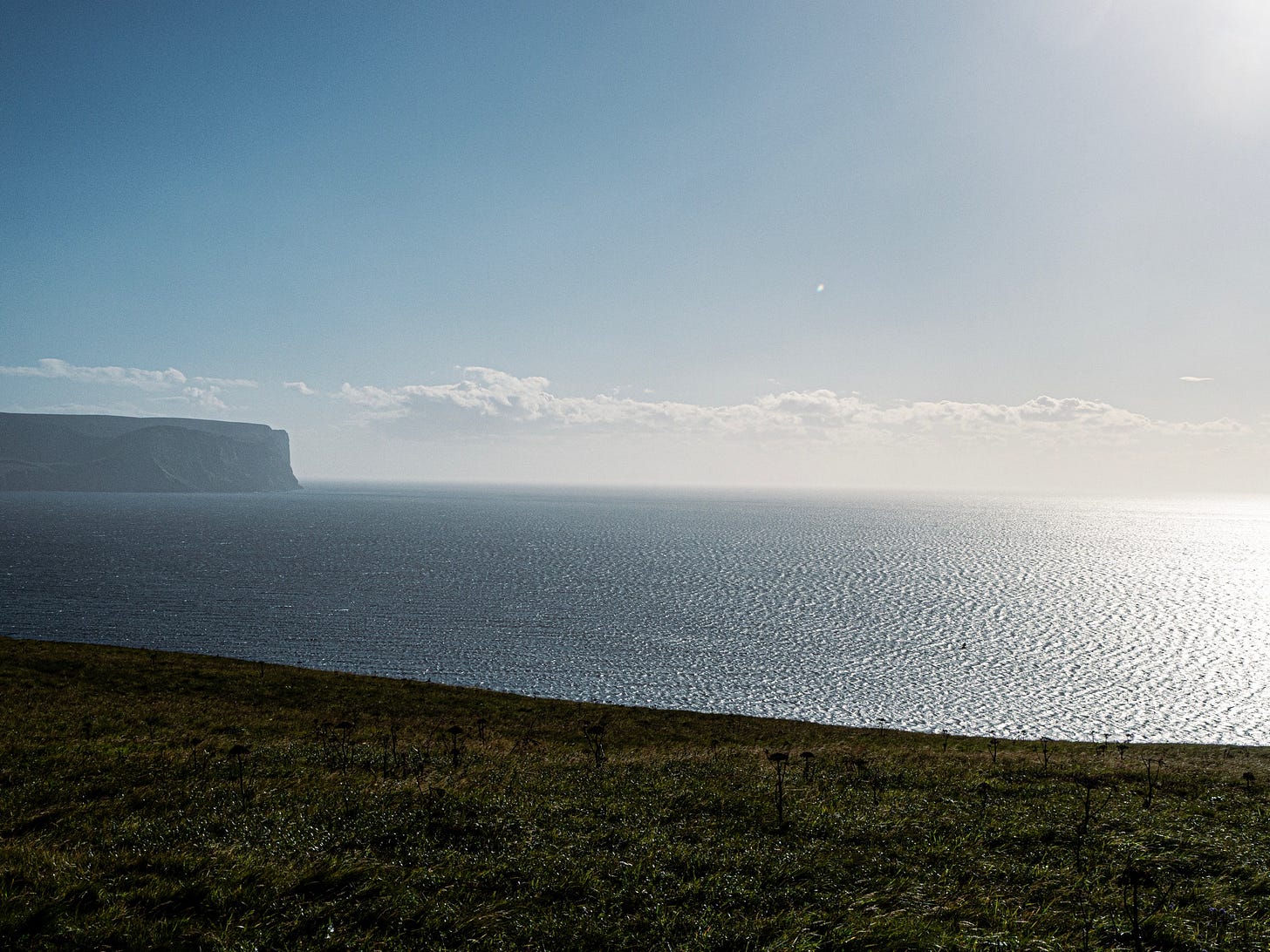 A grassy hill next to a body of water

AI-generated content may be incorrect.